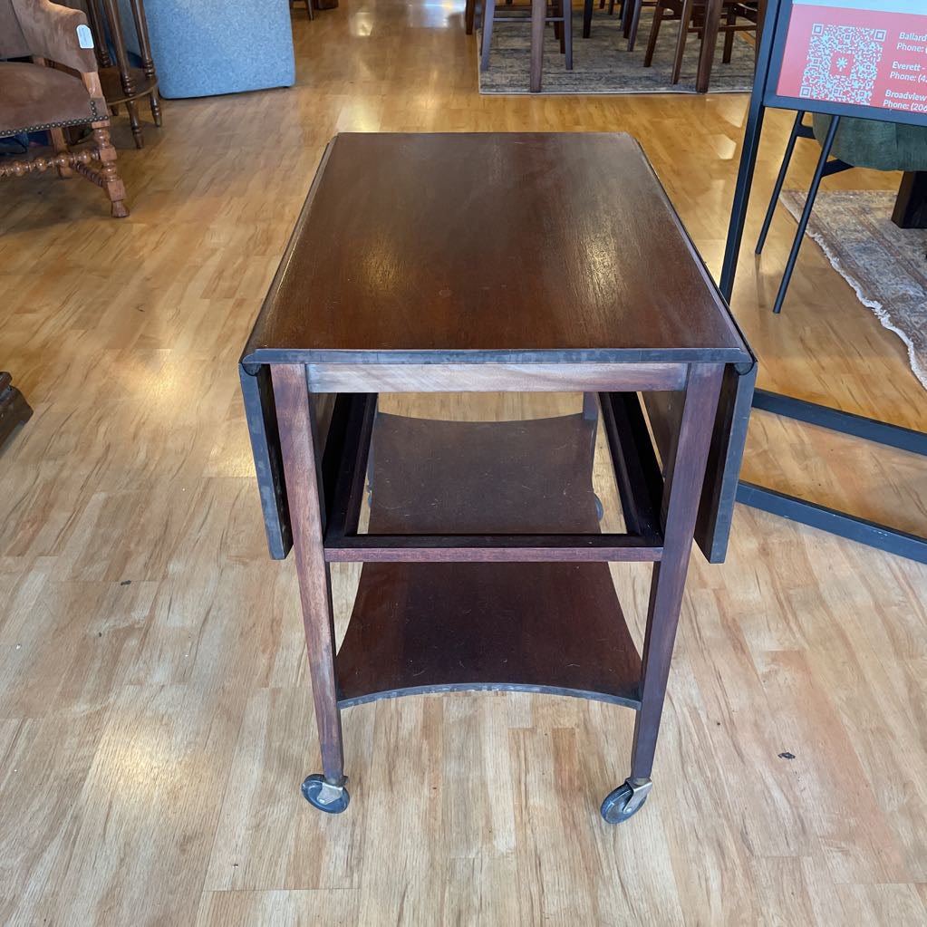 Wooden table with wheels on a wooden floor in an indoor setting