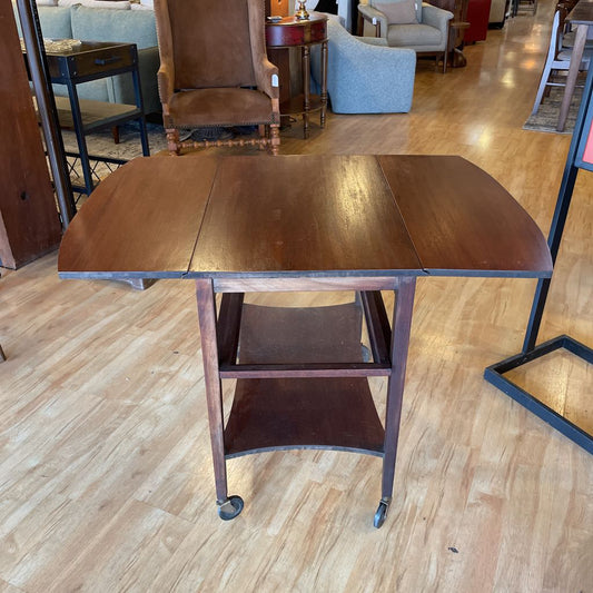 Wooden table with wheels on a wooden floor in a room with furniture.