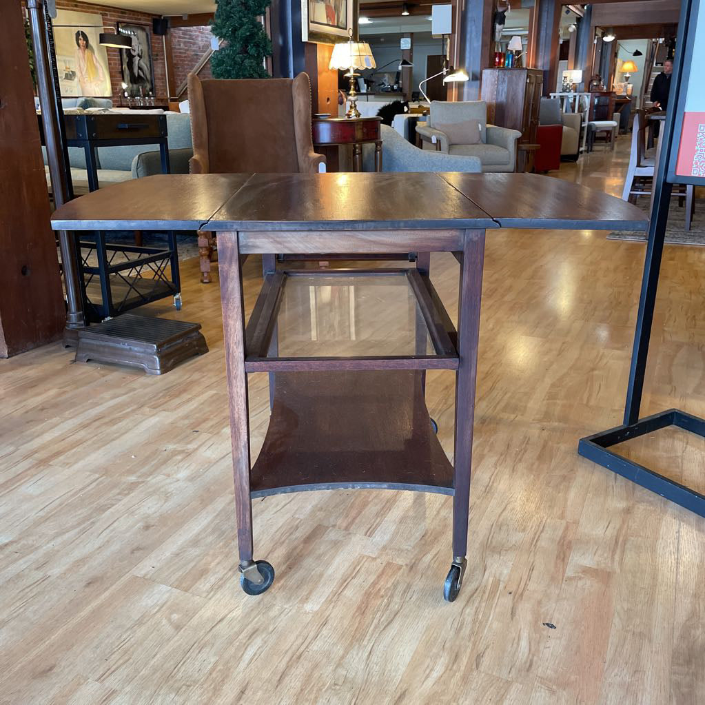 Wooden table with wheels in a room with chairs and decor