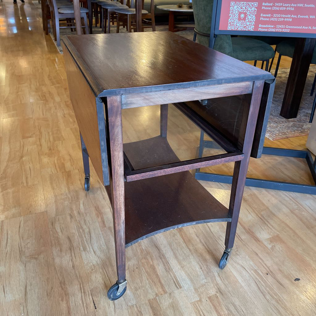 Wooden rolling cart on a wooden floor in an indoor setting