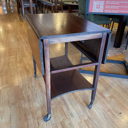 Wooden rolling cart on a wooden floor in an indoor setting