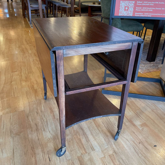 Wooden rolling cart on a wooden floor in an indoor setting