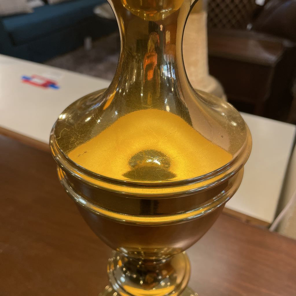 Glass container with a yellowish liquid on a wooden surface