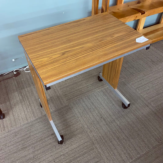 Wooden desk with wheels on a carpeted floor