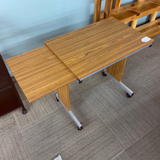 Two wooden desks with metal legs on a gray carpeted floor.