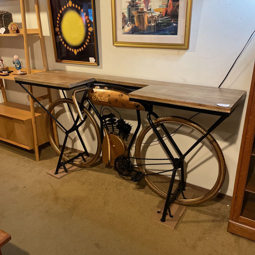 Bicycle converted into a table with wooden top in a room setting