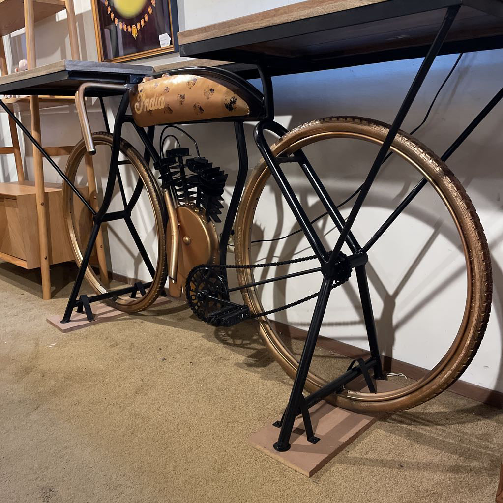 Bicycle on display with wooden seat and black frame against a white wall.