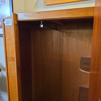 Wooden wardrobe with open door showing empty interior