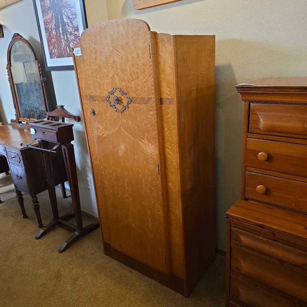 Wooden wardrobe and dresser in a room with beige carpet and wall.
