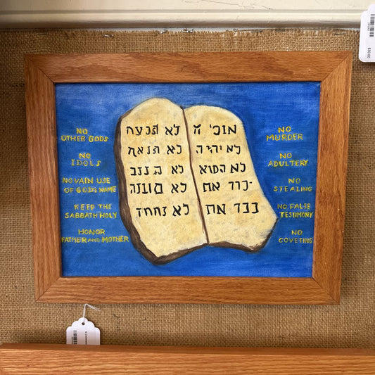 Framed artwork of the Ten Commandments on a blue background with wooden frame.
