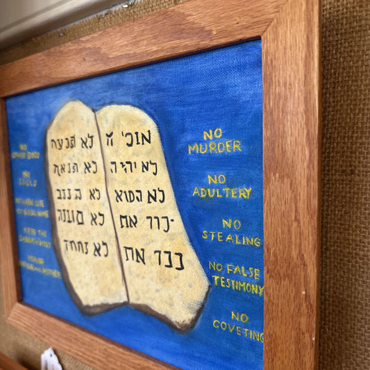 Framed artwork of two stone tablets with Ten Commandments text on a blue background.