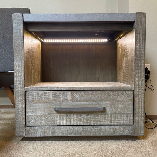 Wooden nightstand with a drawer and LED lighting on a carpeted floor.