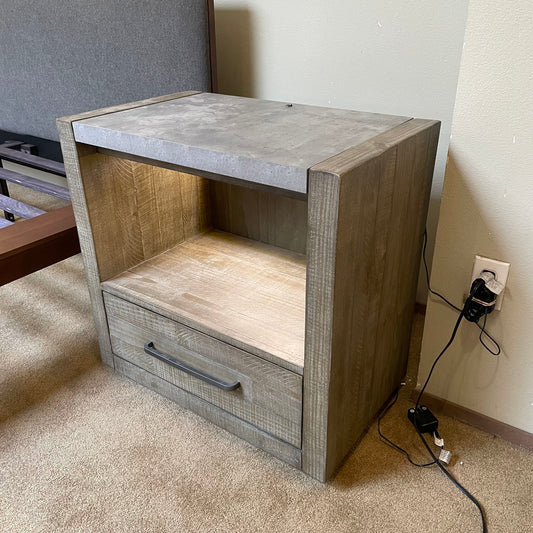 Wooden nightstand with concrete top in a room setting