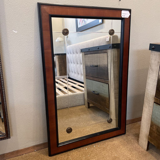 Large mirror with wooden frame on a wall in a room setting