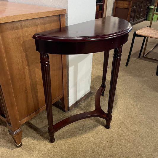 Wooden half-moon table in a room with furniture