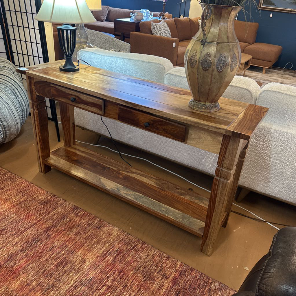 Wooden console table with a vase on top in a living room setting