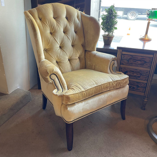Beige armchair with tufted backrest in a room setting