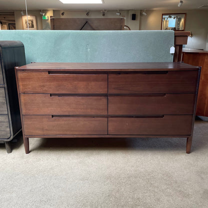 Wooden dresser with multiple drawers in a room setting