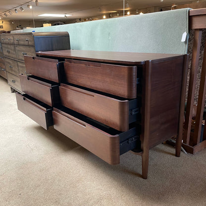 Wooden dresser with multiple drawers in a store setting