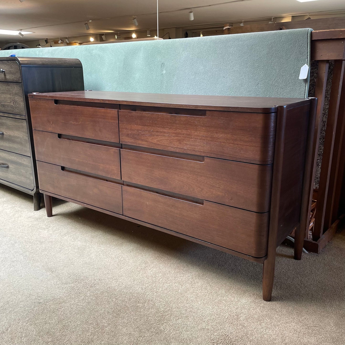 Wooden dresser with multiple drawers in a store setting