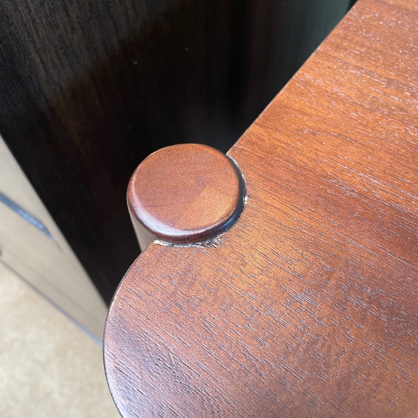 Close-up of a wooden chair leg with a visible screw.