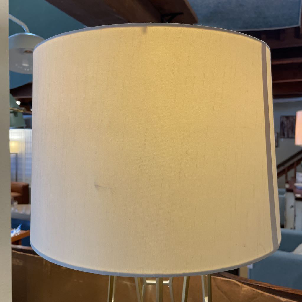 Close-up of a beige lampshade with a blurred indoor setting in the background