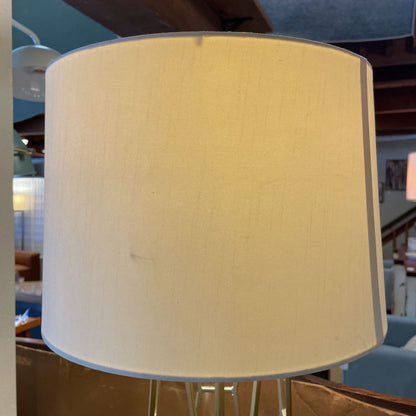 Close-up of a beige lampshade with a blurred indoor setting in the background