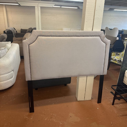 Gray upholstered chair with black legs in a showroom setting