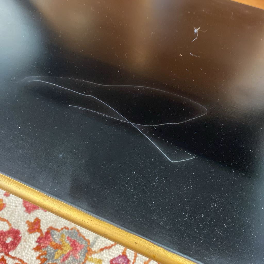Scratch on a car window with a patterned rug at the bottom