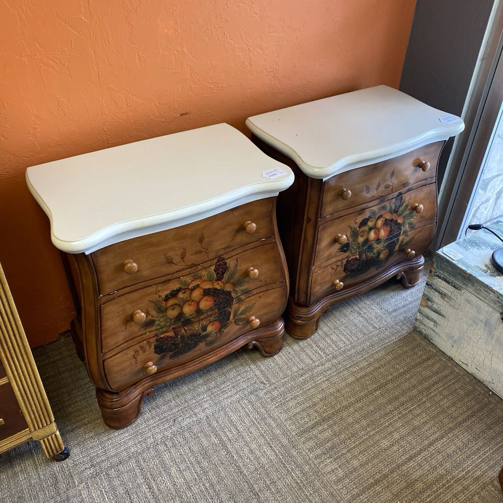Pair of wooden nightstands with white tops against a wall.