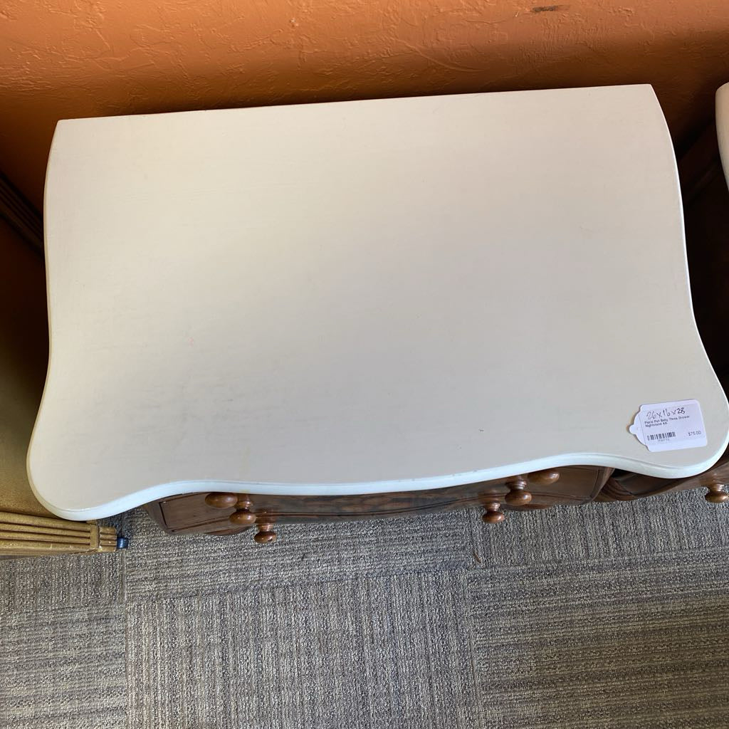 Beige ottoman with wooden legs on a carpeted floor