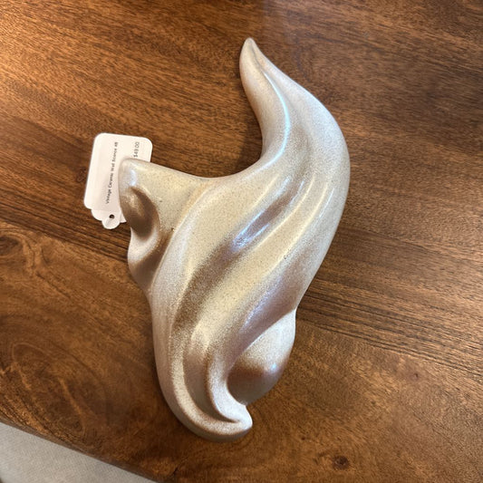 Decorative wall hook with a textured surface on a wooden surface