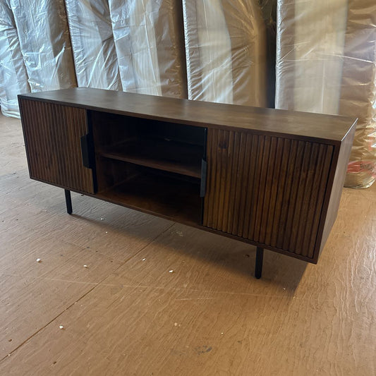 Wooden entertainment console on a wooden floor with plastic sheeting in the background