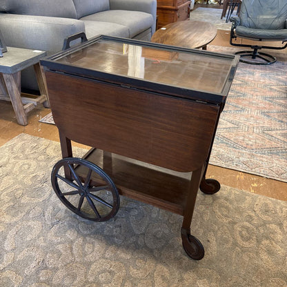 Wooden serving cart with a metal top in a room setting