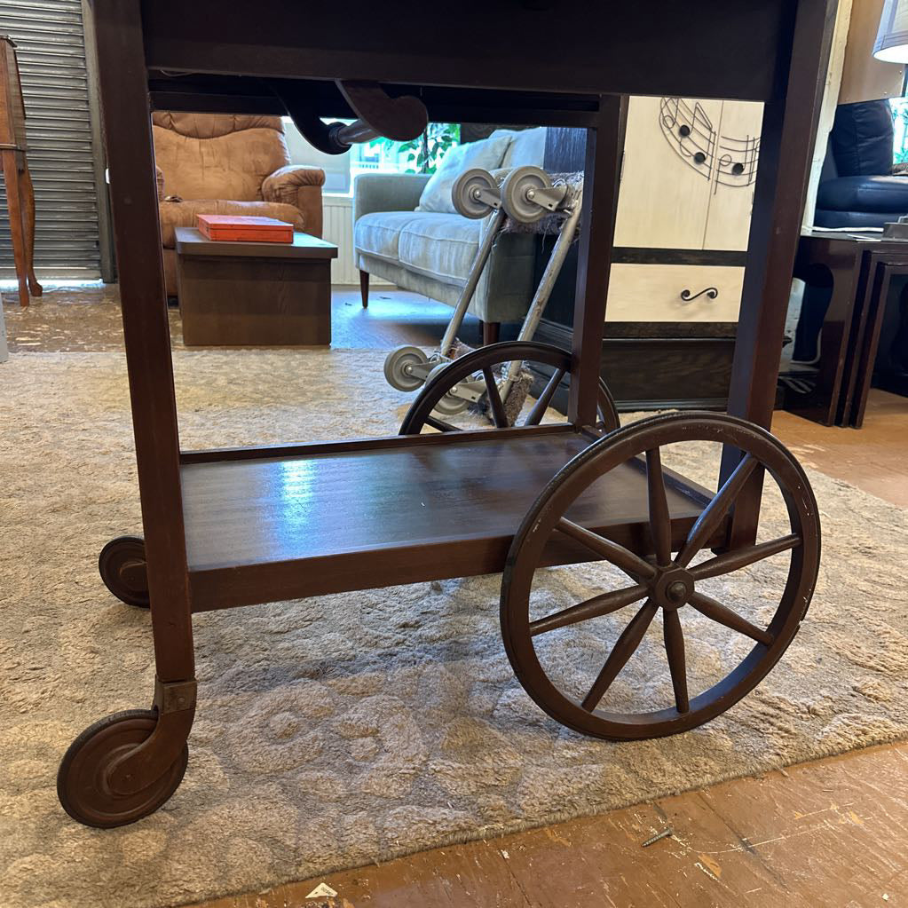 Wooden cart with wheels in a room with furniture and decor.
