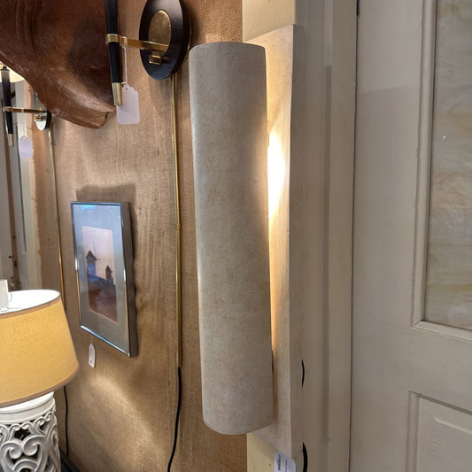 Decorative wall sconces on a beige wall with a door in the background