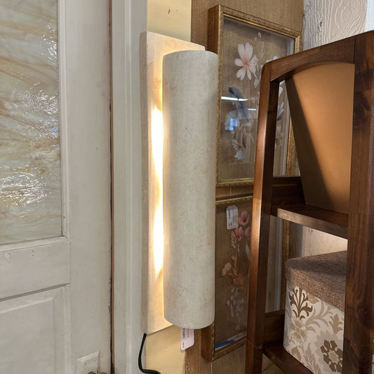 Decorative wall sconce with a floral mirror in a home setting
