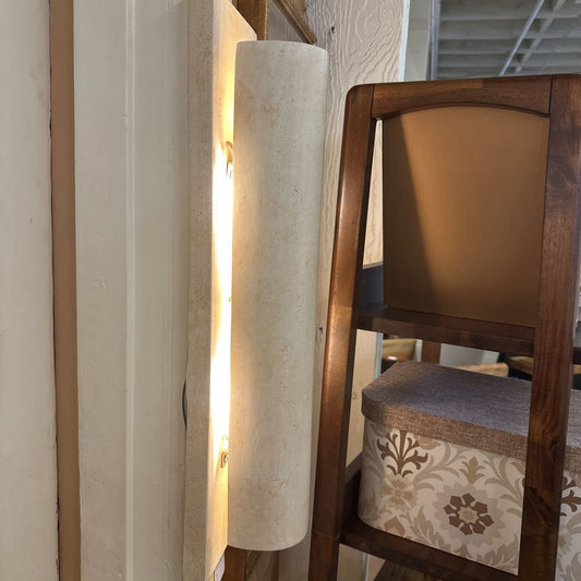 Wooden chair with patterned cushion next to a cylindrical light fixture.
