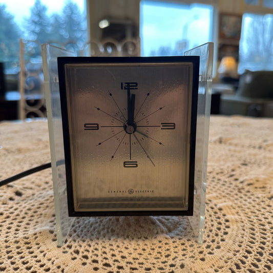 Vintage General Electric clock on a textured surface with a blurred background
