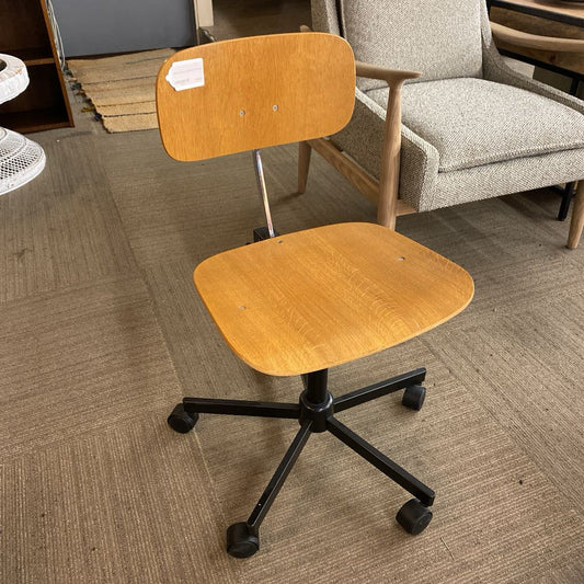 Wooden office chair with black wheels on a carpeted floor