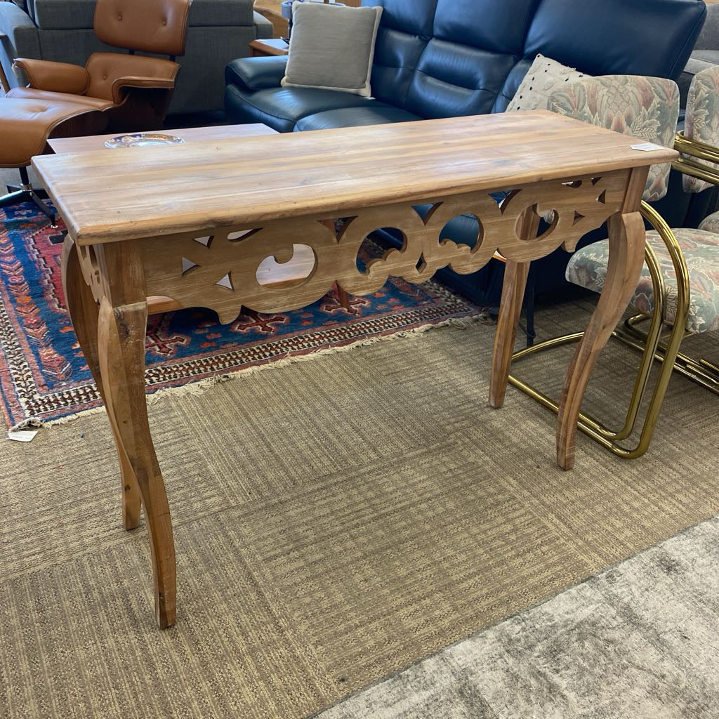 Wooden console table in a room with furniture and a rug.