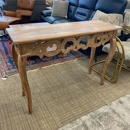 Wooden console table in a room with furniture and a rug.