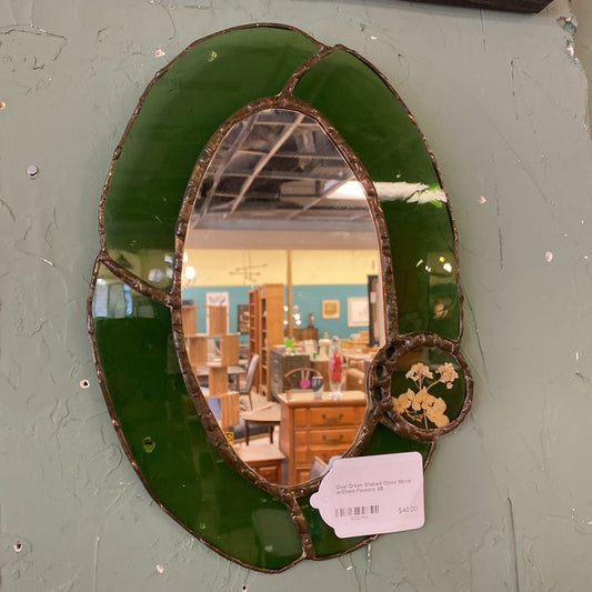 Decorative mirror with green glass frame on a gray wall