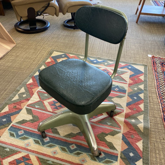 Black office chair on a patterned rug with a blurred background
