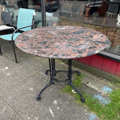 Round marble-top bistro table with black cast iron base